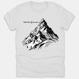 A white t-shirt featuring a black line-art mountain graphic with text reading faith like a seed can move mountains.