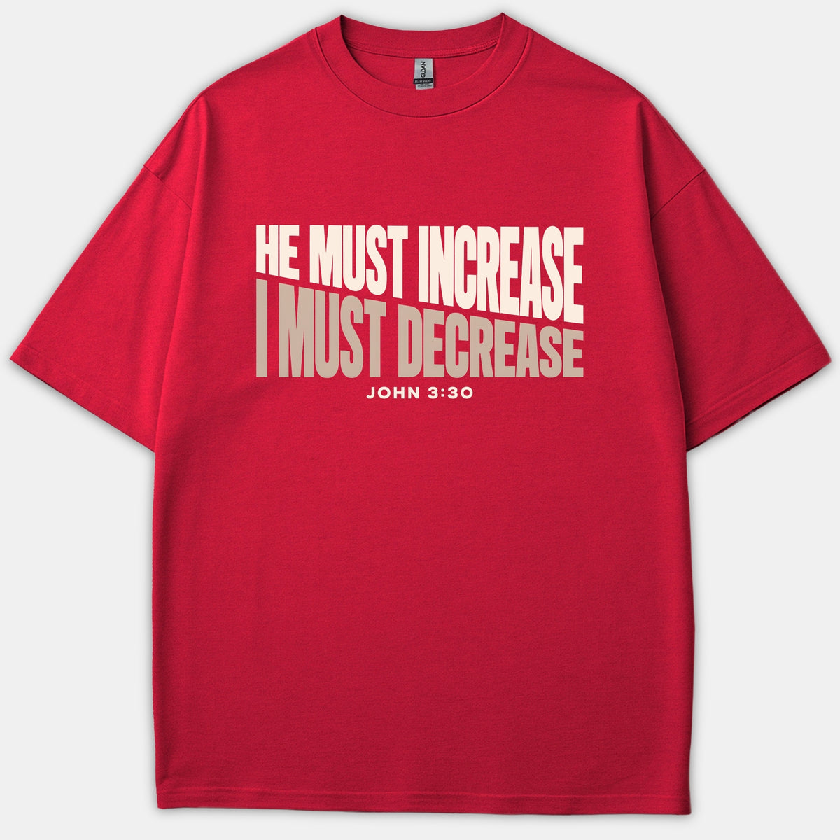 A red Christian t-shirt featuring the bold text HE MUST INCREASE in white and I MUST DECREASE in beige, with the Bible verse reference JOHN 3:30 underneath.