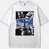 A white Christian t-shirt featuring a graphic design of a judge's gavel revealing a cross against a colorful sunset sky with the word JUSTIFIED.