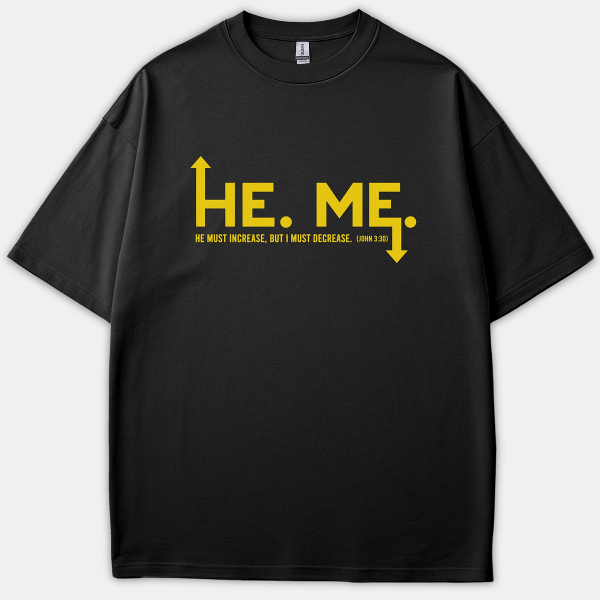 A black Christian t-shirt featuring yellow graphic text reading 'HE. ME.' with directional arrows and the scripture reference John 3:30.