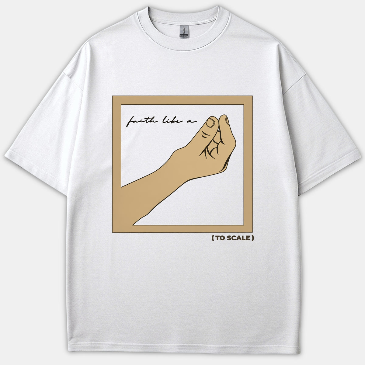 A white t-shirt featuring a framed illustration of a hand pinching a microscopic seed with the text 'faith like a' inside and '(TO SCALE)' printed below.