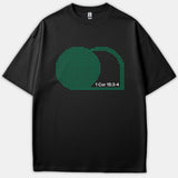 A black t-shirt featuring a green halftone graphic depicting an empty tomb alongside the scripture reference 1 Cor 15:3-4 printed in white.