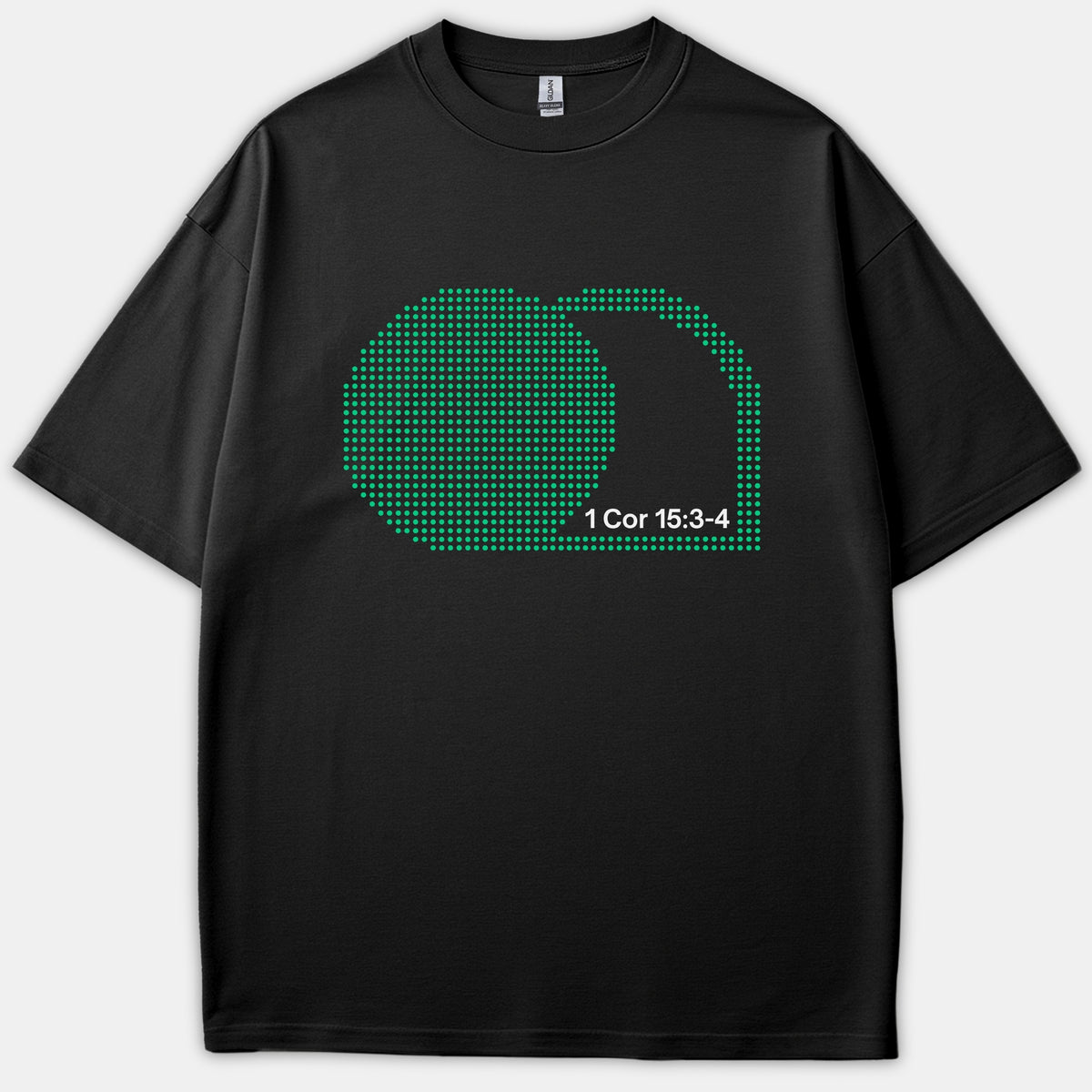 A black t-shirt featuring a green halftone graphic depicting an empty tomb alongside the scripture reference 1 Cor 15:3-4 printed in white.