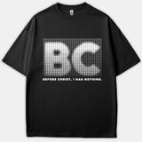 A black t-shirt featuring a white halftone dot graphic of the initials BC above the text BEFORE CHRIST, I HAD NOTHING.