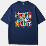 A navy blue t-shirt featuring a colorful ransom-note style graphic that reads Encoded by the Spirit surrounded by tech accessories like a router, hard drive, and USB drive.