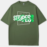 An olive green Christian t-shirt featuring a bold 3D graphic design that reads 'BY HIS STRIPES WE ARE HEALED' in white and bright green typography.