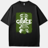 A black T-shirt featuring a green distressed graphic of a gavel with white text reading 'God's Verdict: Grace' and the Bible reference 'Romans 8:1'.