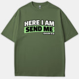A green Christian t-shirt featuring the scripture phrase HERE I AM SEND ME ISAIAH 6:8 printed across the chest in bold white and black lettering.