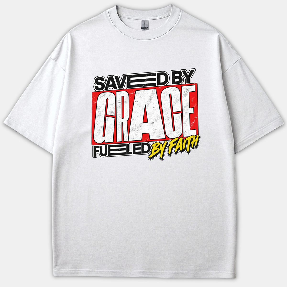 A white Christian t-shirt displaying a bold graphic print that reads 'Saved By Grace Fueled By Faith' in red, black, white, and yellow typography.
