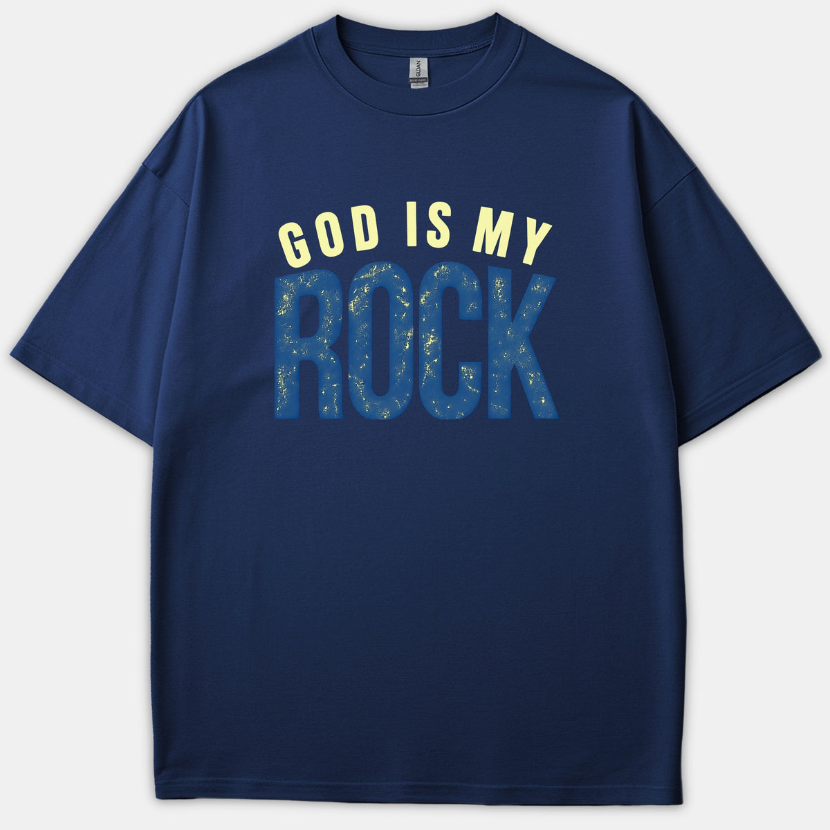 A navy blue Christian t-shirt featuring the phrase 'GOD IS MY ROCK' printed in light yellow and textured blue typography across the chest.