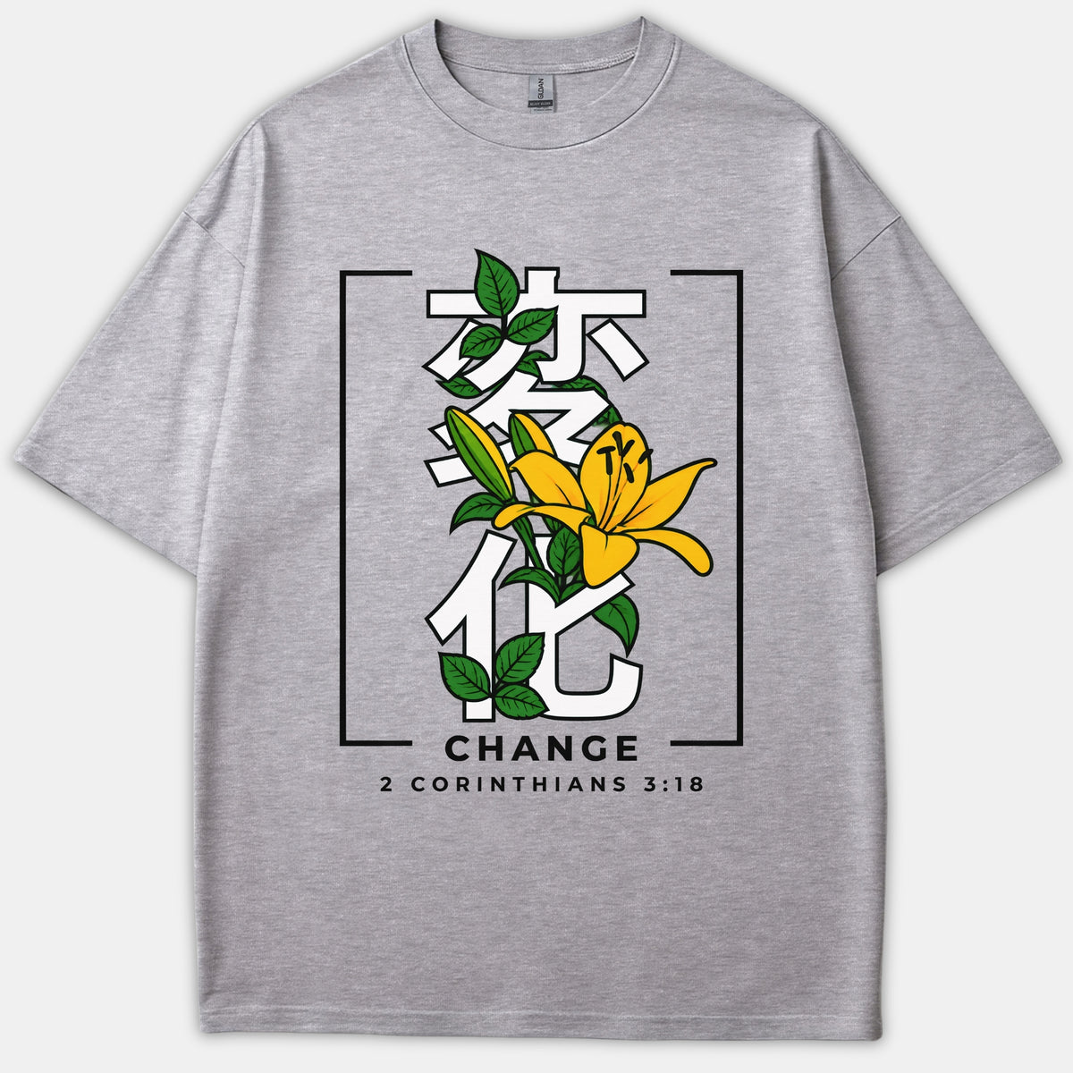 A gray t-shirt featuring a yellow lily flower and green leaves woven through white Japanese characters, with the word CHANGE and 2 Corinthians 3:18 printed below.