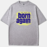 A gray t-shirt featuring a light yellow brushstroke graphic background with purple text reading 'YOU MUST BE born again JOHN 3:7'.