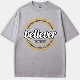 A gray Christian T-shirt featuring a circular black and yellow graphic design with the word 'believer' in bold script and scripture text from John 3:36.
