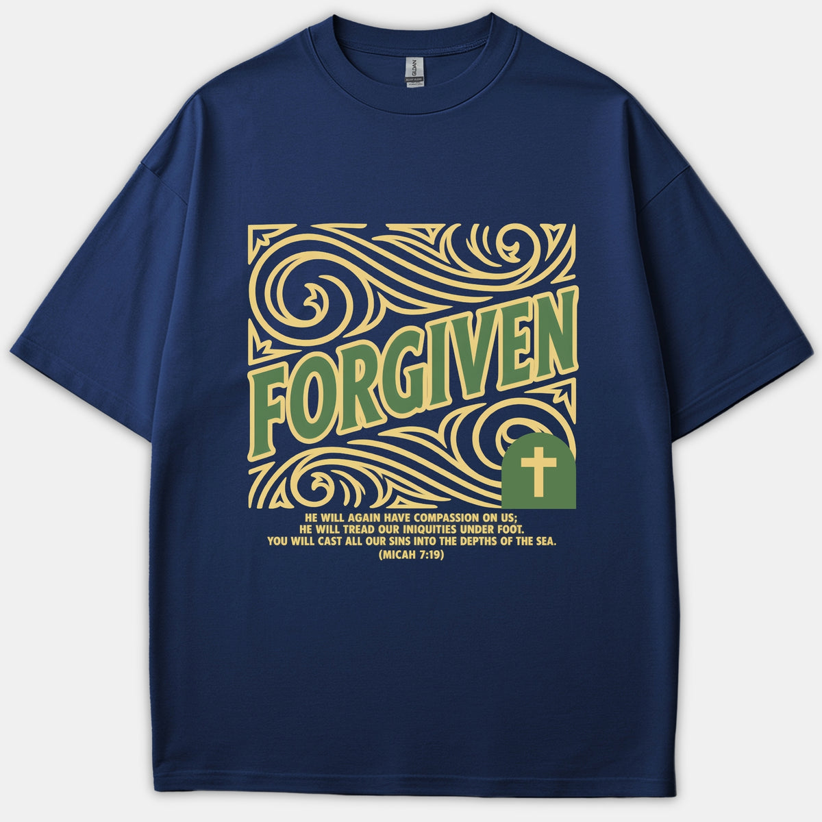 A navy blue Christian t-shirt featuring a yellow ornate swirly design with the word FORGIVEN in green, a cross emblem, and Micah 7:19 scripture.