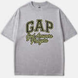 A gray Christian t-shirt featuring an athletic-style GAP logo with the phrase 'God Answers Prayers' printed in gold, black, and white.