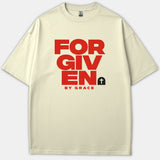 A beige Christian T-shirt featuring bold red text that reads FORGIVEN BY GRACE accompanied by a small black tombstone icon with a white cross.