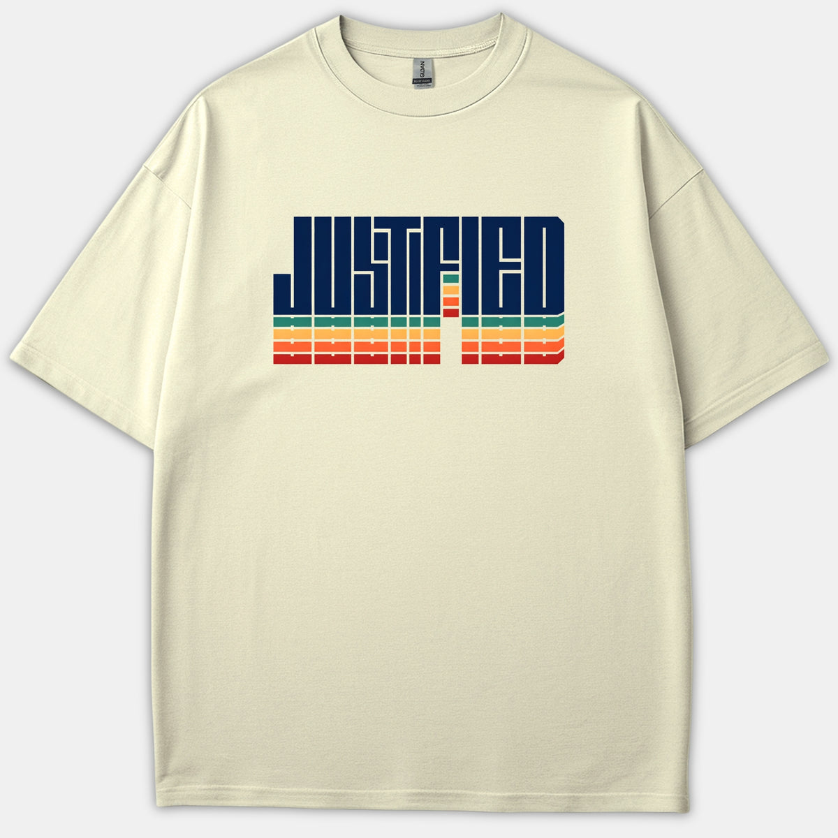 A beige t-shirt featuring the word JUSTIFIED in bold navy typography with colorful retro stripes across the chest.