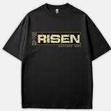 A black T-shirt featuring a distressed beige graphic that reads HE IS RISEN alongside the scripture reference MATTHEW 28:6.