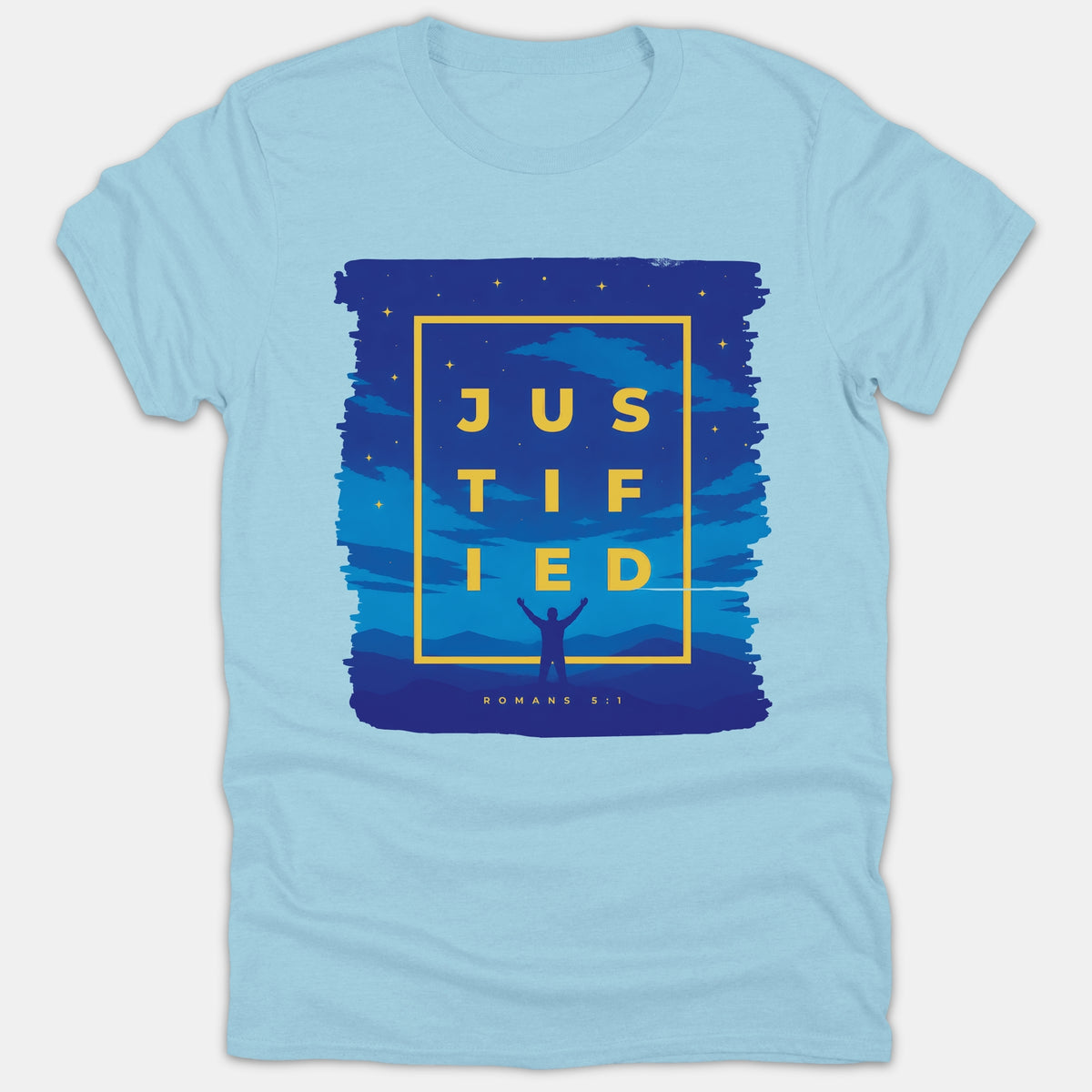 A light blue Christian t-shirt featuring yellow text reading Justified Romans 5:1 set inside a box over a starry blue night sky landscape with a silhouette raising hands in worship.
