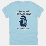 A light blue t-shirt featuring a cute cartoon character wearing glasses and holding a Bible, surrounded by the text 'I have decided to follow Jesus, no turning back.'