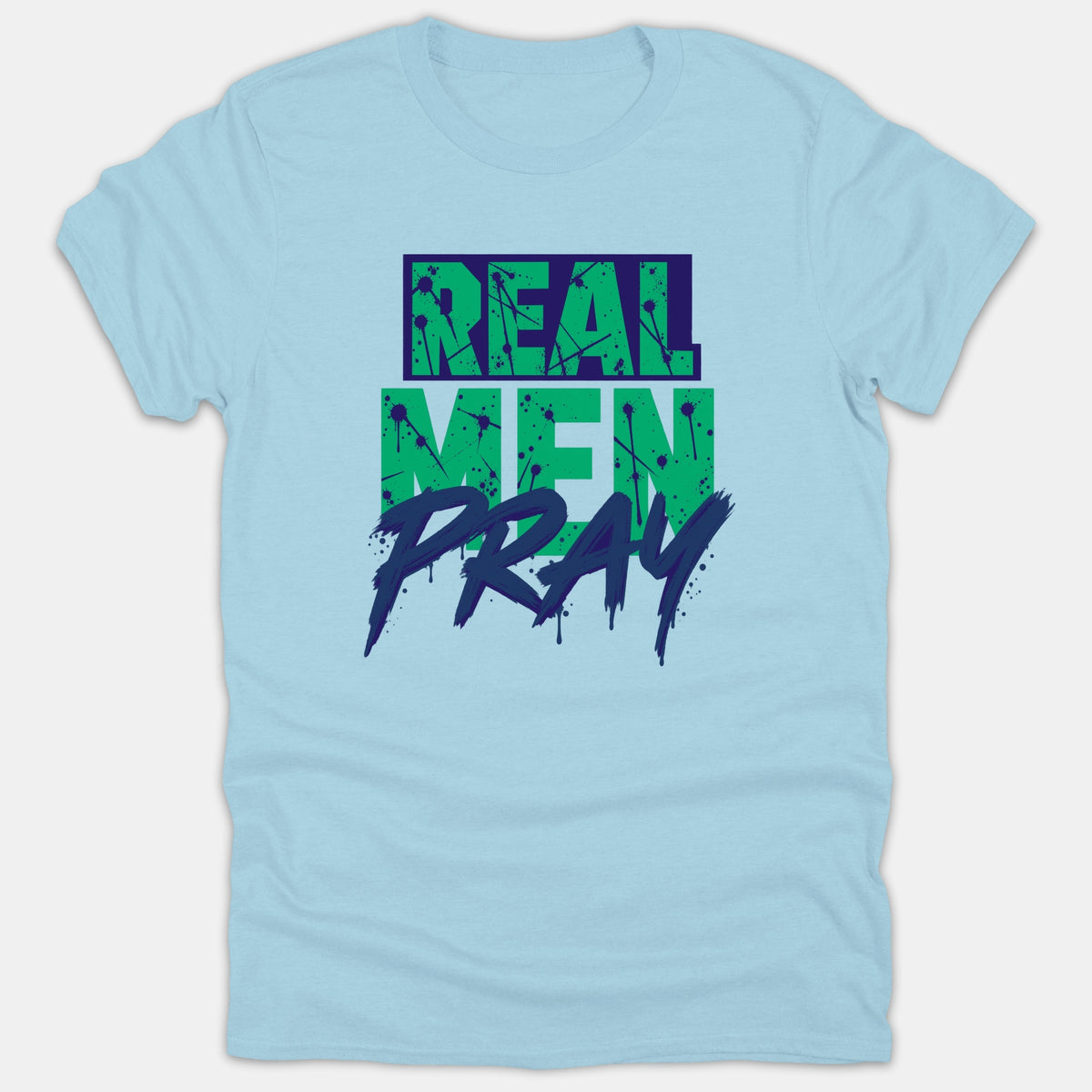 A light blue t-shirt featuring a bold graphic design with the phrase REAL MEN PRAY printed in green and navy distressed splatter lettering.