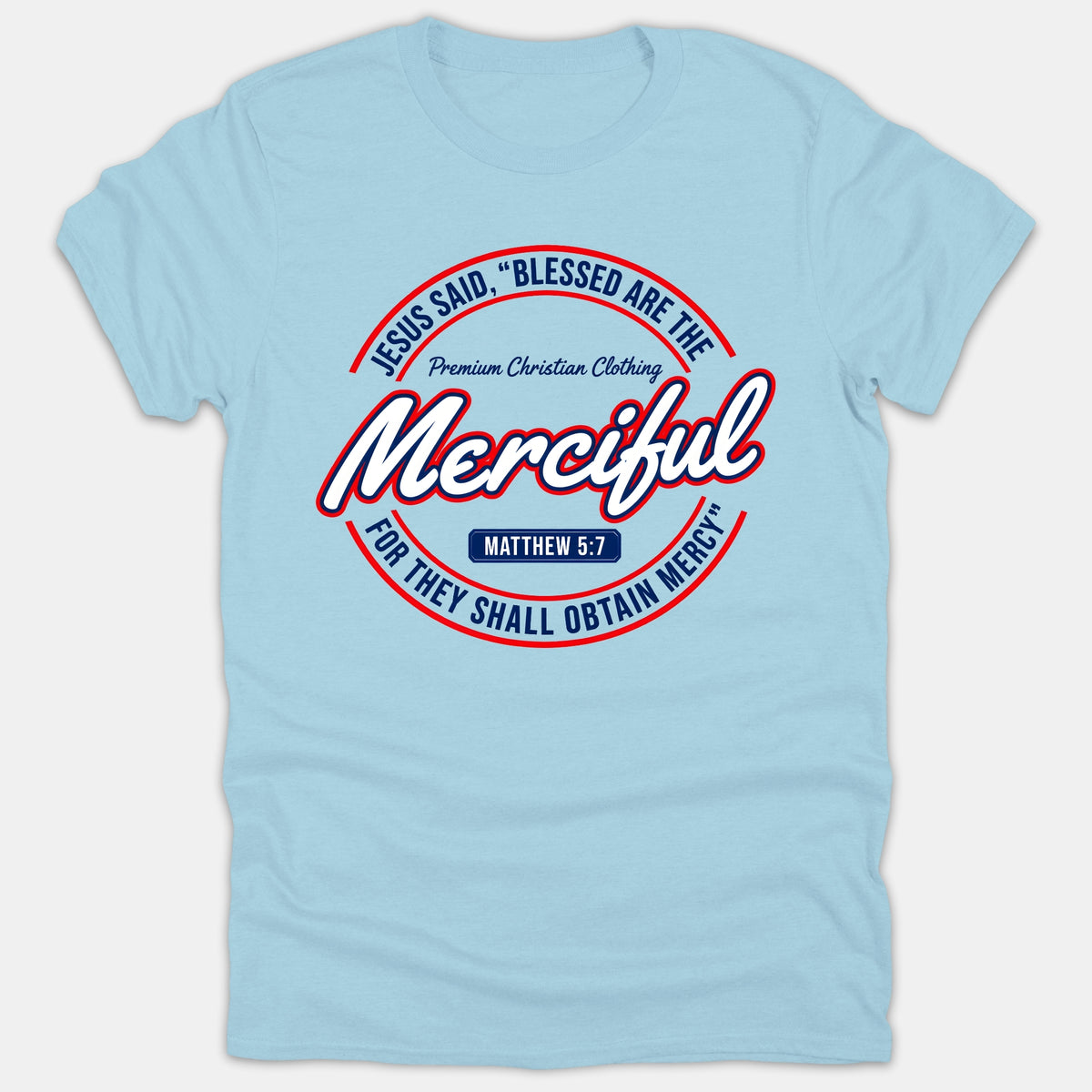 A light blue Christian t-shirt featuring a circular emblem graphic with the verse Matthew 5:7, 'Blessed Are The Merciful', printed in red, white, and navy blue.