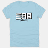 A light blue Christian t-shirt featuring bold white 3D Japanese kanji text above the English caption [3RD DAY] in black lettering.