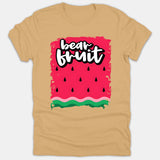 A beige Christian t-shirt featuring a stylized watermelon graphic with black seeds and green rind, displaying the words 'bear fruit' in bold white script.