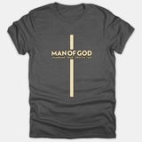 A dark gray Christian t-shirt featuring a tall cross graphic with the text MAN OF GOD HUSBAND DAD PROTECTOR printed across the center in beige and black.