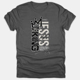 A dark gray t-shirt featuring a graffiti-style graphic that reads 'Jesus Is King' with a crown and scripture reference from Revelation 17:14.