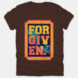 A brown t-shirt featuring a framed graphic print with the word FORGIVEN in bold, distressed yellow and orange lettering against a dark blue background.
