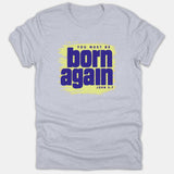 A heather gray Christian t-shirt featuring a yellow paint stroke background with purple text reading 'YOU MUST BE BORN AGAIN' and the Bible reference 'JOHN 3:7'.