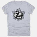 A light gray Christian t-shirt featuring a circular graphic styled like cracked stone revealing the bold black phrase For God So Loved The World.