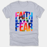 A light gray t-shirt featuring vibrant, colorful brushstroke typography reading FAITH OVER FEAR printed across the chest.
