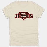 A beige Christian t-shirt featuring the name JESUS styled with a bold black and red superhero shield logo in the center.