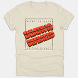 A beige Christian t-shirt featuring a black frame with the text 'JESUS IS ALIVE', bold red 3D graphic text reading 'DEATH IS DEFEATED', and 'THE TOMB IS EMPTY'.